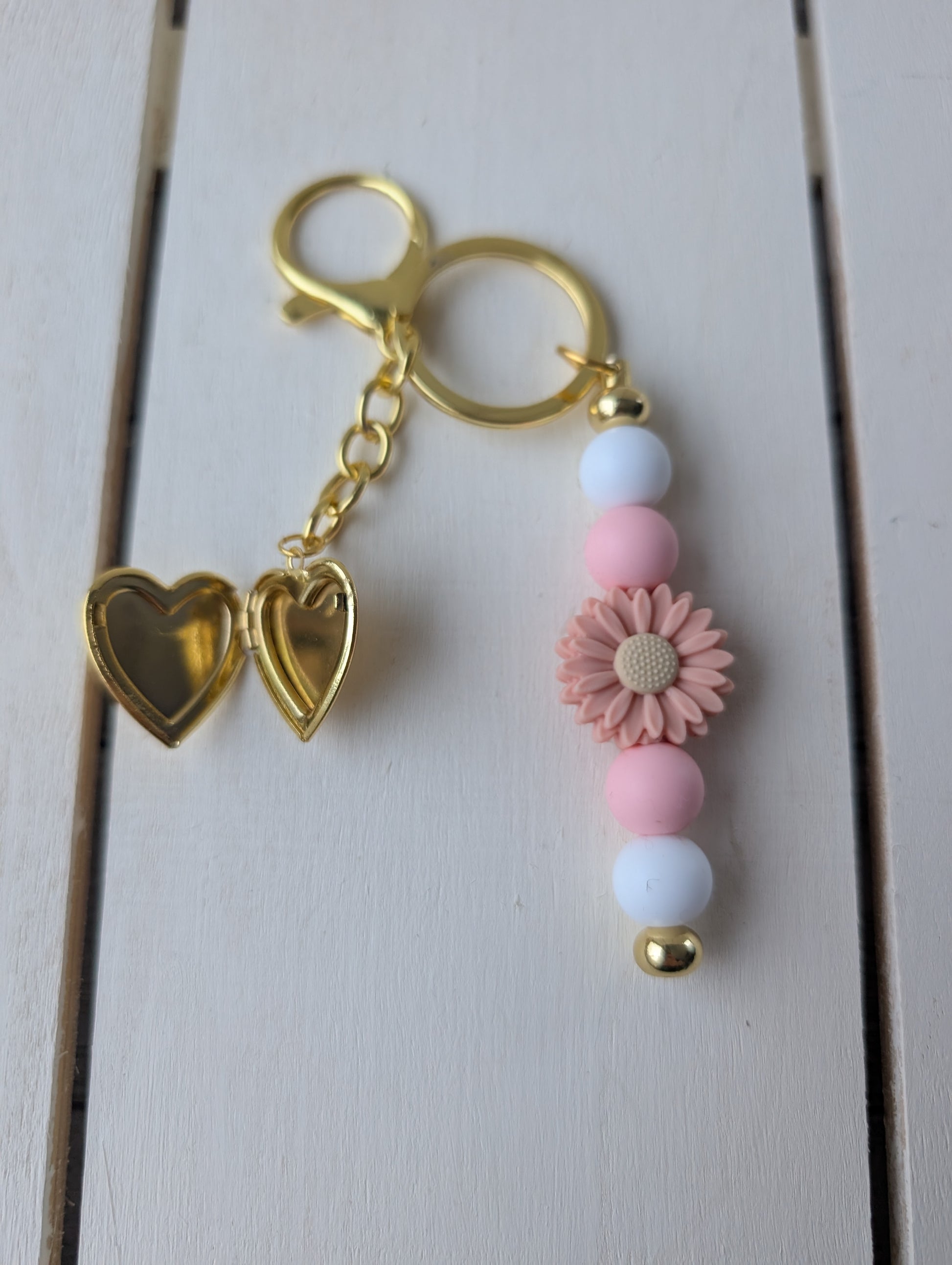Flower keychain with gold heart locket charm.