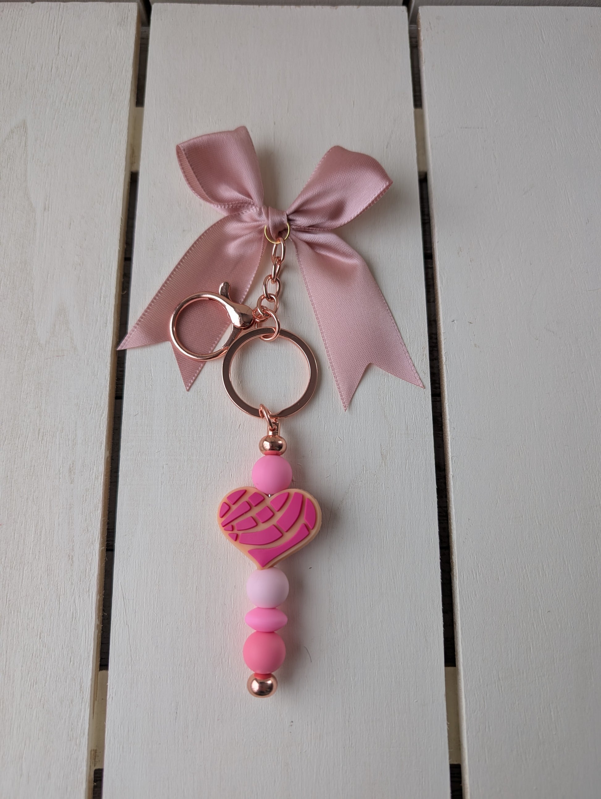 Pink concha bread heart with pink beads and pink bow. Rose gold metal.